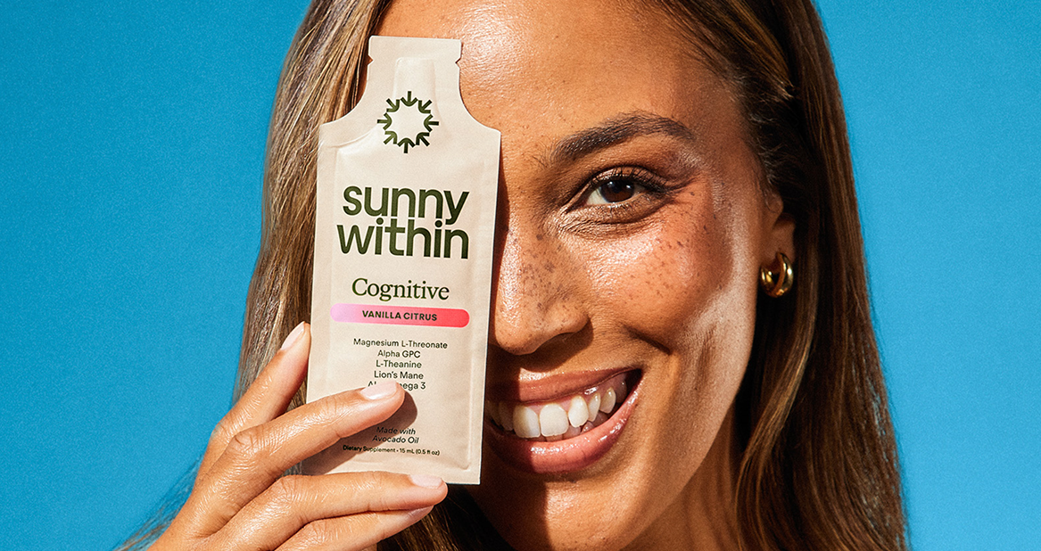 Cognitive 6 supplement - Smiling woman holding Sunny Within product - Energizes mind and nourishes brain health.